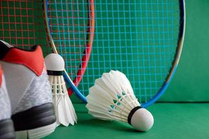 Badminton-Sportgeräte auf grünem Boden von Badminton-Federbällen, Schlägern, Schuhen, selektiver Fokus auf Federbälle, Badminton-Sportliebhaber auf der ganzen Welt. foto