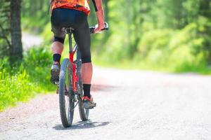 Mountainbike-Fahrer auf der Schotterstraße foto