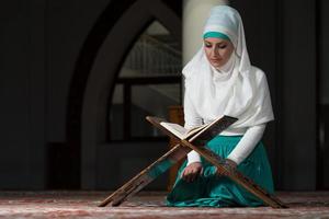 muslimische Frau, die den Koran liest foto