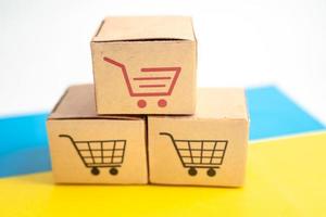 Box mit Online-Shopping-Warenkorb-Logo und ukrainischer Flagge, Import-Export-Shopping online oder Handel Finanzen Lieferservice Store Produktversand, Handel, Lieferantenkonzept. foto