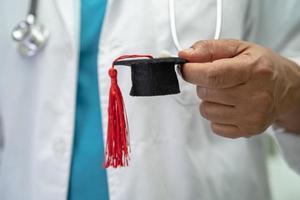 asiatische arztstudie lernen mit abschlusslückenhut in der krankenstation, kluges, geniales bildungsmedizinkonzept. foto