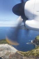 Flugzeug fliegt über die Küste und Turbinendetail in Bewegung foto