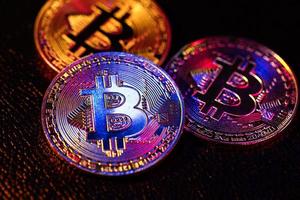 drei Münzen mit Bitcoin-Logo auf schwarzem Hintergrund foto