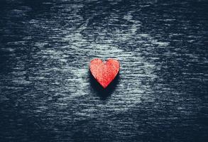 rotes Herz auf dunklem Holzhintergrund foto
