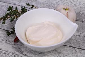 Mayonnaise-Sauce in der weißen Schüssel serviert Thymian und Knoblauch foto