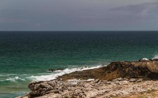 die wellen kämpfen um die verlassene felsige küste des atlantiks, portugal foto