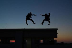 Zwei Männer machen Kampfkunst auf dem Dach foto