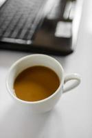 Kaffeetasse und Laptop für Unternehmen, selektiver Fokus auf Kaffee. foto