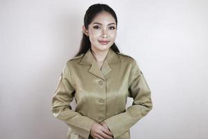 Porträt einer asiatischen Frau in brauner Uniform, die in die Kamera lächelt. uniform der indonesischen regierungsangestellten. foto