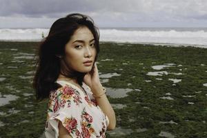 Ein junges asiatisches Mädchen am Strand starrt in Gunungkidul, Indonesien, in die Kamera foto