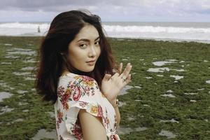 Ein junges asiatisches Mädchen am Strand lächelt in Gunungkidul, Indonesien, in die Kamera foto