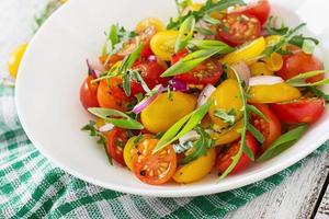 Salat aus frischen Kirschtomaten mit Zwiebeln und Rucola foto