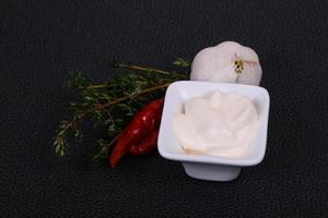 Mayonnaise-Sauce in der weißen Schüssel serviert Thymian und Knoblauch foto