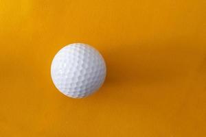 Golfball auf einem orangefarbenen Hintergrund foto