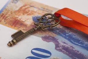 Schlüssel zum Erfolg mit roter Schleife auf Schweizer Franken foto
