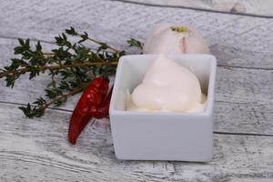 Mayonnaise-Sauce in der weißen Schüssel serviert Thymian und Knoblauch foto