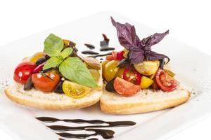 Saftige Tomaten auf frischem Brot, Pesto als Topping foto