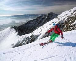Skifahrer Skifahren bergab im Hochgebirge gegen Sonnenuntergang