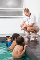 süße Kinder im Schwimmbad hören Trainer