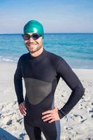 lächelnder Schwimmer, der sich am Strand fertig macht foto
