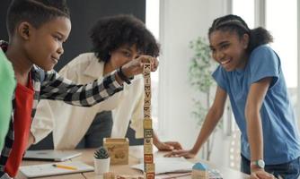 afroamerikanischer lehrer und schüler, der aktivitäten macht, die holzblöcke für die entwicklung spielen, zusammen mit spaß und spaß im klassenzimmer. foto