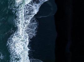 island schwarzer sandstrand mit riesigen wellen bei reynisfjara vik. foto