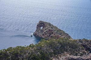 Blick aus der Vogelperspektive auf die blaue mediterrane Meereslandschaft durch felsige Klippen an sonnigen Tagen foto