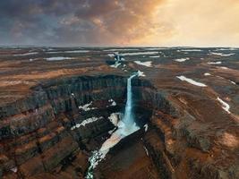 Luftaufnahme des Hengifoss-Wasserfalls mit Sedimenten mit roten Streifen in Island. foto