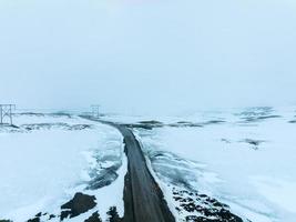 endlose straße in die bewölkten berge und hügel von island bei sonnigem bewölktem wetter. foto