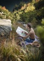 junge frau auf einer wanderung, die auf einem felsen sitzt foto