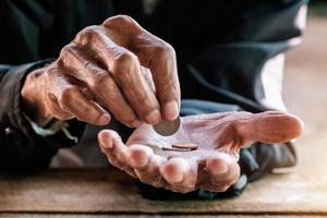 Hand alter Mann, der wegen des Hungers um Geld bettelt Vintage-Ton foto