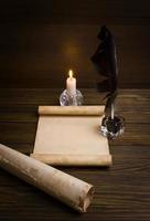Feder, altes Papier und Kerze auf einem hölzernen Hintergrund