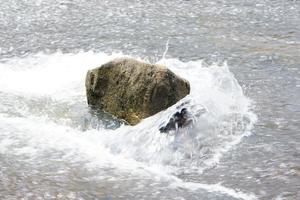 Stein, der von Wasser in einem Bach getroffen wurde foto