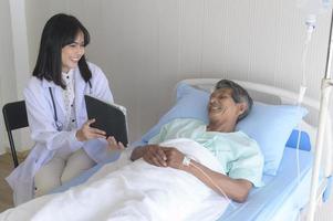 asiatischer älterer männlicher patient berät und besucht arzt im krankenhaus.. foto