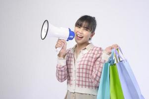 attraktive Käuferfrau, die Einkaufstaschen über weißem Hintergrund hält foto