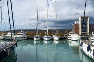 segelboote, die mit reflexionen auf dem wasser festgemacht sind foto