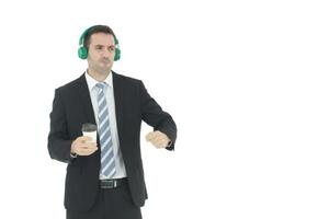 Schöner und intelligenter Geschäftsmann entspannen sich beim Hören von Musik in grünen Kopfhörern und halten eine Tasse Kaffee in der Hand, die auf weißem Hintergrund isoliert ist. Geschäfts- und Finanzkonzept. Platz kopieren foto