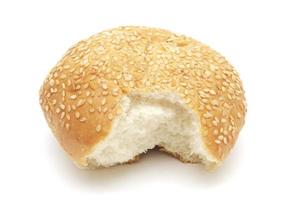 ein gebissenes Burgerbrötchen mit Sesam isoliert auf weißem Hintergrund foto