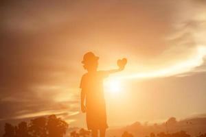 Kindersilhouette, Momente der Freude des Kindes. auf dem natursonnenuntergang foto