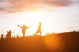 silhouette eines glücklichen kinder- und glücklichen zeitsonnenuntergangs foto