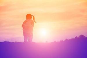 Kindersilhouette, Momente der Freude des Kindes. auf dem natursonnenuntergang foto