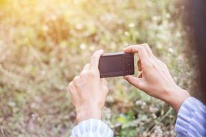 kleines Mädchen fotografiert Blume im Freien foto