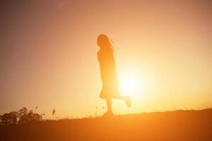 Silhouette einer jungen Frau, die allein steht foto