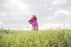 junge Frau spielte in einer Blumenwiese in der Winterluft. foto