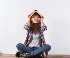 junge Hipster-Frau, die Bücher hält und auf isolierten weißen Hintergrund zeigt. foto