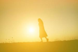 Silhouette einer jungen Frau, die allein steht foto