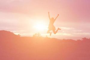 Silhouette einer Frau, die über einem schönen Himmelshintergrund betet foto