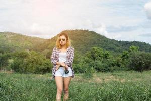 jahrgang der schönen frauenfotografie stehende hand, die retro-kamera mit sonnenaufgang hält, weicher traumstil foto