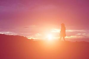 Silhouette einer Frau, die über einem schönen Himmelshintergrund betet foto