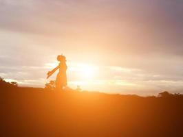 Silhouette einer Frau, die über einem schönen Himmelshintergrund betet foto